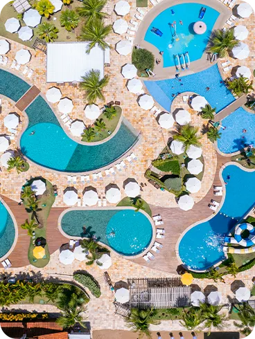 Vista aérea del parque acuático Salinas Maragogi Vista aérea del gran complejo de piscinas de Salinas Maragogi, que muestra las piscinas de formas orgánicas, las terrazas de madera, las sombrillas blancas y el parque acuático infantil.