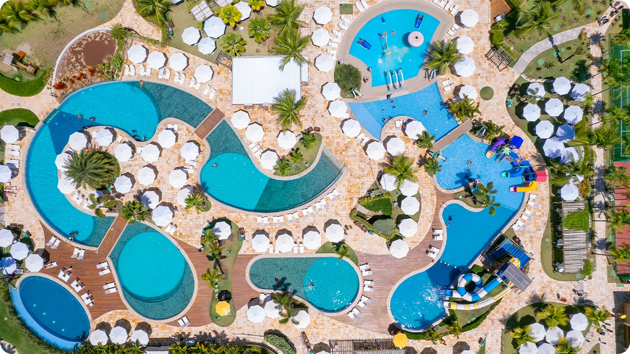 Vista aérea del parque acuático Salinas Maragogi Vista aérea del gran complejo de piscinas de Salinas Maragogi, que muestra las piscinas de formas orgánicas, las terrazas de madera, las sombrillas blancas y el parque acuático infantil.