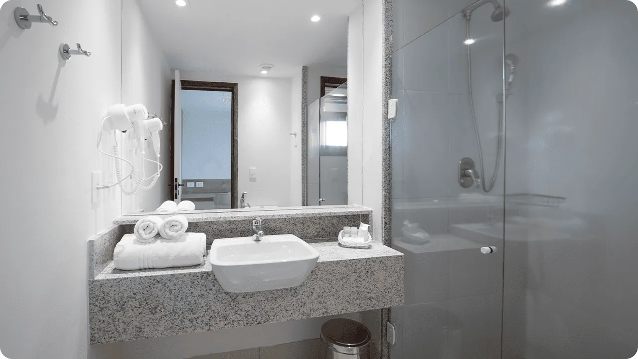 banheiro da acomodação standard Banheiro da acomodação Standard, contendo área pra banho, instalações sanitárias, chuveiro com regulação de temperatura, decoração, amenities O Boticário, toalhas, grande espelho e secador de cabelo.