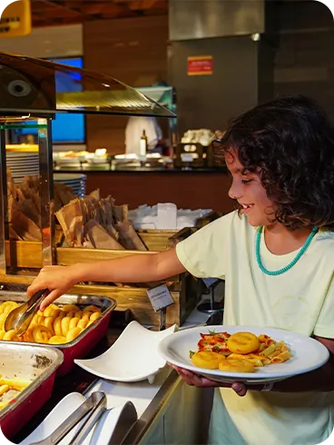 All Inclusive para crianças Criança se servindo de batatas fritas no buffet infantil do restaurante do Salinas Maragogi.
