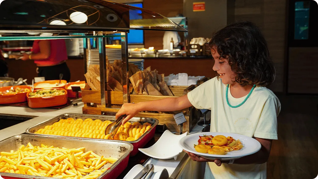 All Inclusive para crianças Criança se servindo de batatas fritas no buffet infantil do restaurante do Salinas Maragogi.