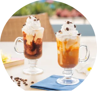 Café da tarde com aquele charme que apenas o resort All inclusive tem Cafés gelados com chantilly, calda de chocolate e caramelo servidos em canecas de vidro com grãos de café e flores decorativas.