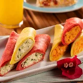 Cores e sabores no café da manhã Crepiocas coloridas recheadas acompanhadas de suco de laranja