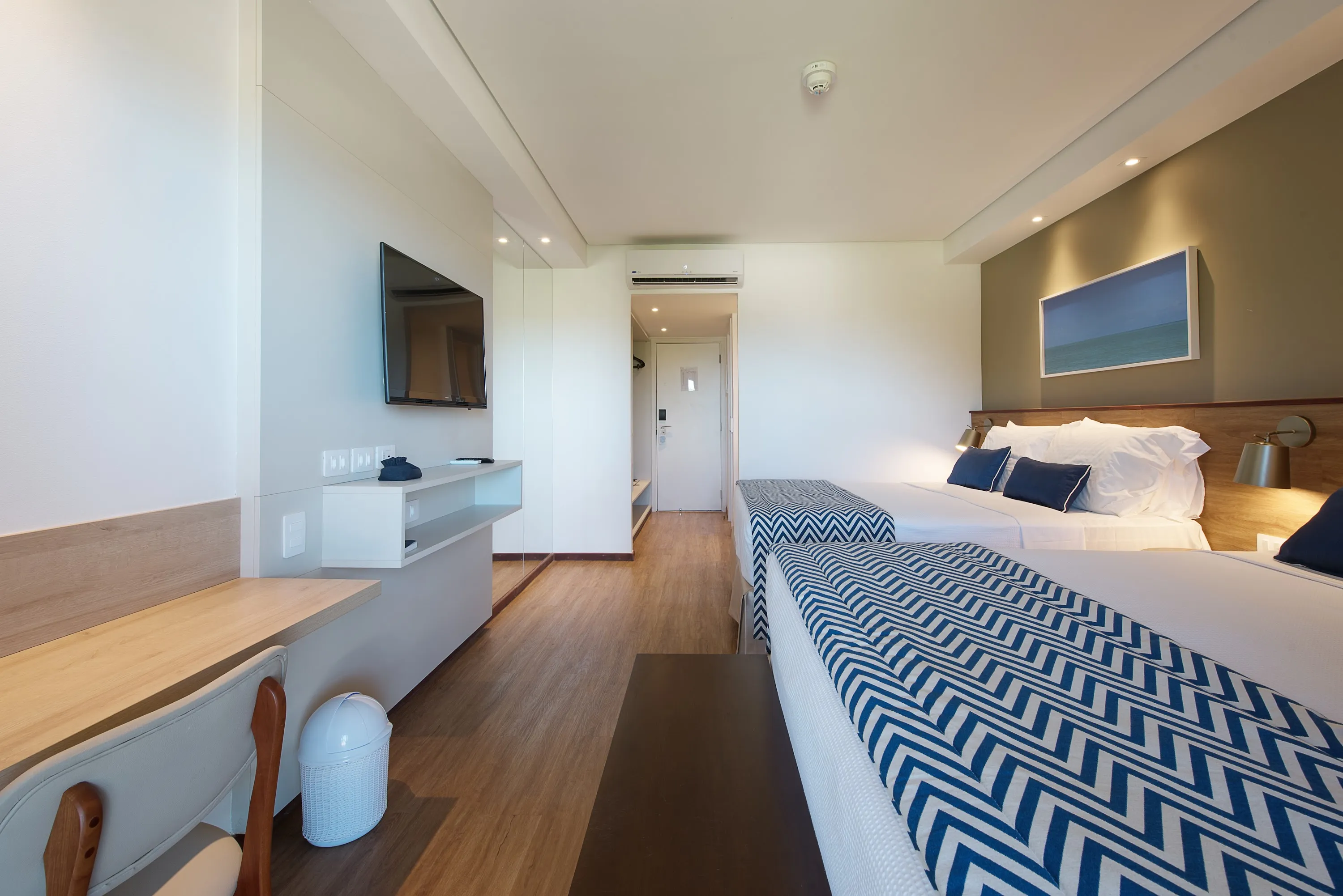 Alojamiento frente a la playa Otra vista del alojamiento, con dos camas queen, un escritorio con sillas, un panel de TV por cable, una decoración acogedora, fotografías enmarcadas de las playas de Maragogi y una puerta de entrada.