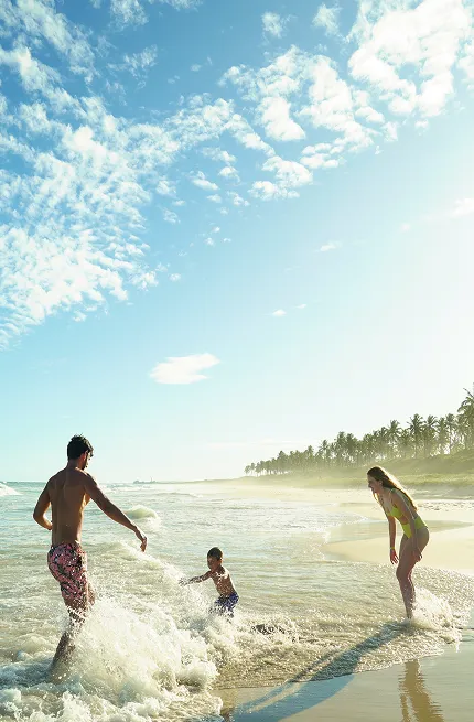 promocoes salinas maceió Família feliz brincado nas ondas do mar na Praia do Francês, um dos destinos próximos ao Salinas Maceió, em dia ensolarado.
