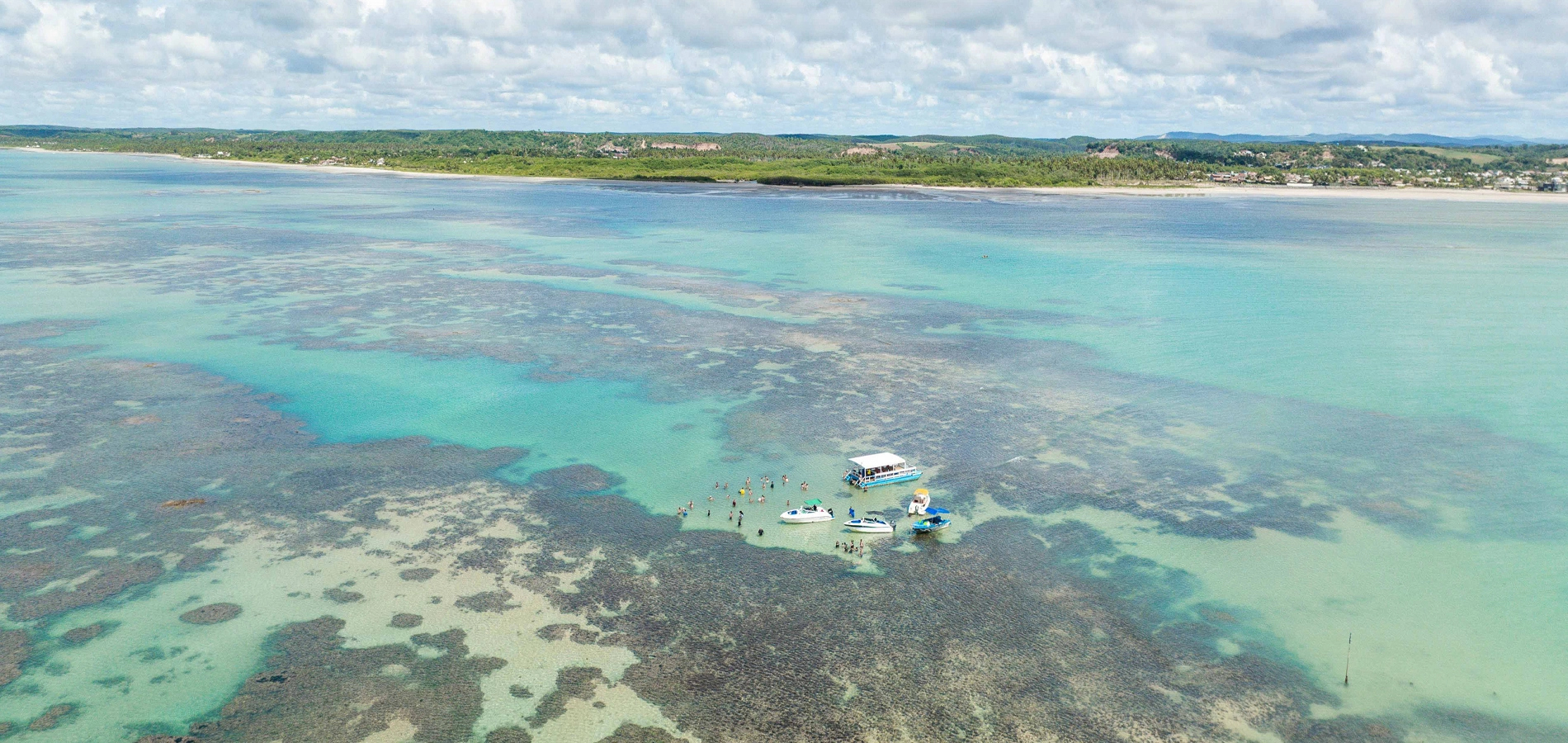 Tábua de marés Maceió Vista aérea das piscinas naturais de Maceió com águas rasas, recifes de corais e embarcações turísticas