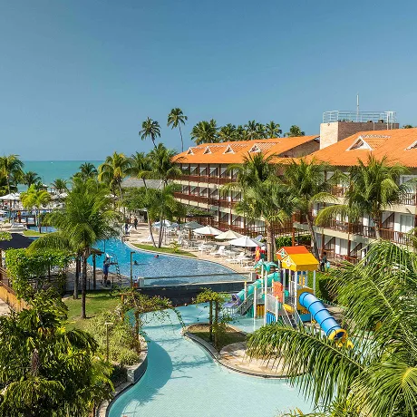 Resort Salinas Maceió Vista do resort Salinas Maceió com as piscinas, área recreativa para crianças e a praia ao fundo.