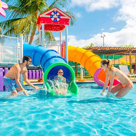 Diversão em família no resort Salinas Maragogi Família se divertindo no parque aquático do Resort Salinas Maragogi, com escorregador e brinquedos coloridos