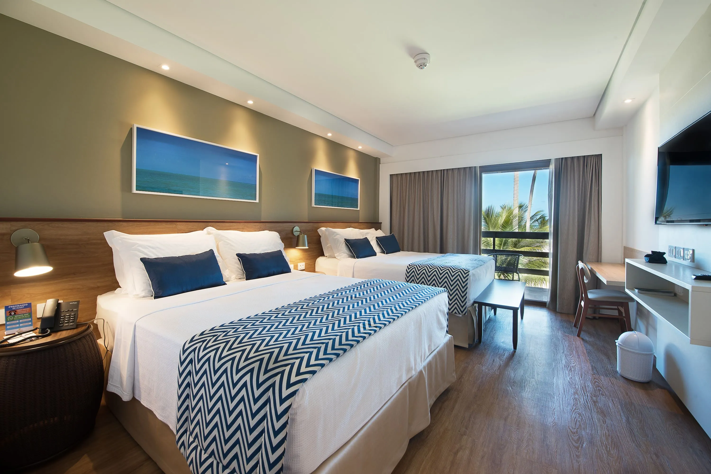 Apartamento frente a la playa Detalles del apartamento frente a la playa, con dos camas queen, mesa y sillas, pantalla de TV por cable, decoración acogedora, fotografías enmarcadas de las playas de Maragogi y balcón con vista al mar.