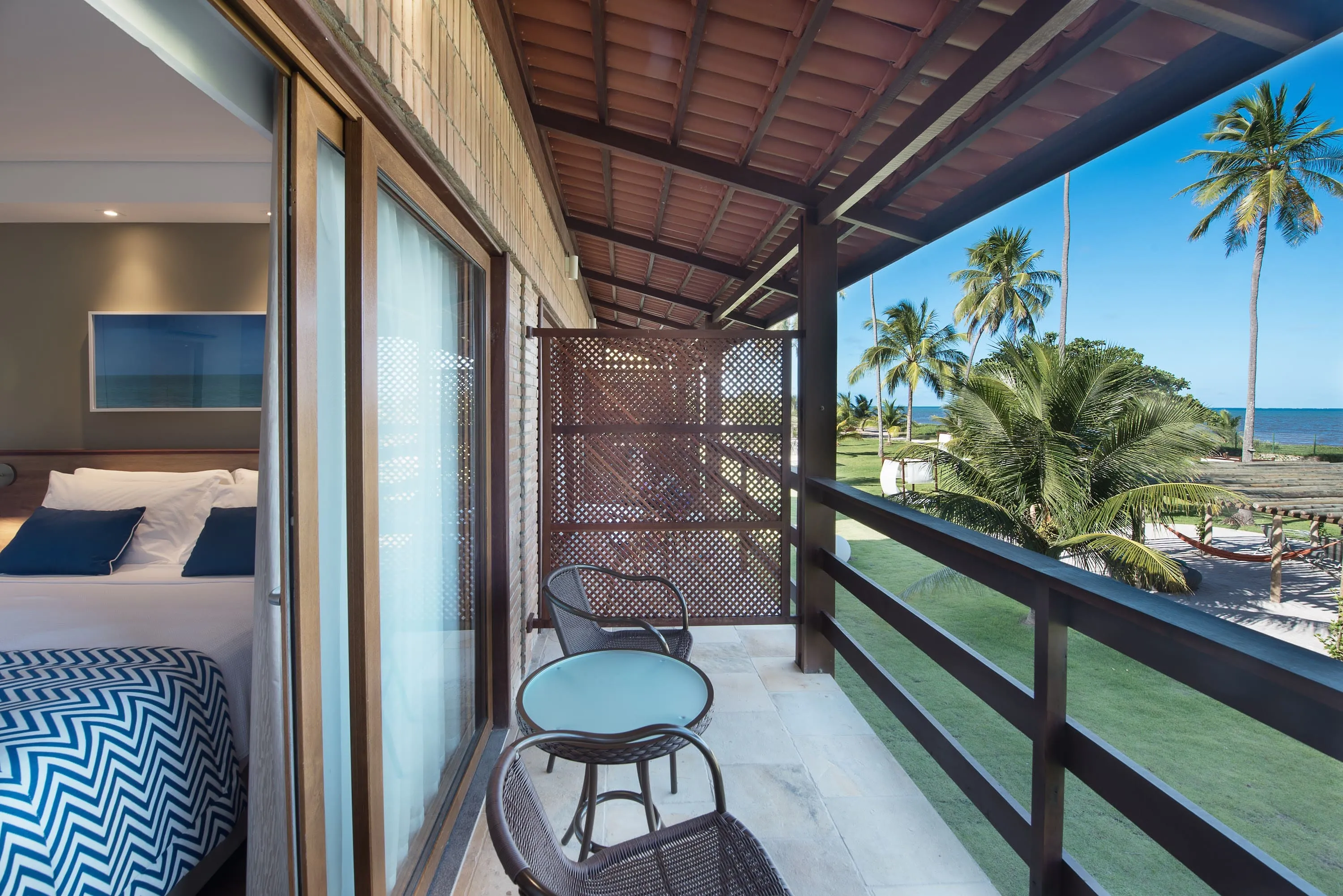Balcón del apartamento frente a la playa Balcón del apartamento frente a la playa, con mesa, dos sillas y vista al mar azul turquesa de la playa de Maragogi.