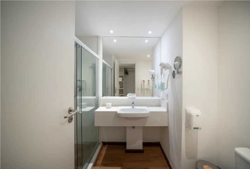baño playa jardin Baño del alojamiento Playa Jardín, con zona de baño, sanitarios, ducha con control de temperatura, decoración, artículos de aseo O Boticário, toallas, espejo grande y secador de pelo.