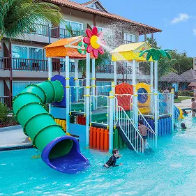 Piscina infantil do Salinas Maceió Crianças e adultos brincam na piscina infantil do Salinas Maceió, que possui um grande toboágua verde e brinquedos coloridos dentro da piscina de água azul, com os prédios do resort ao fundo.