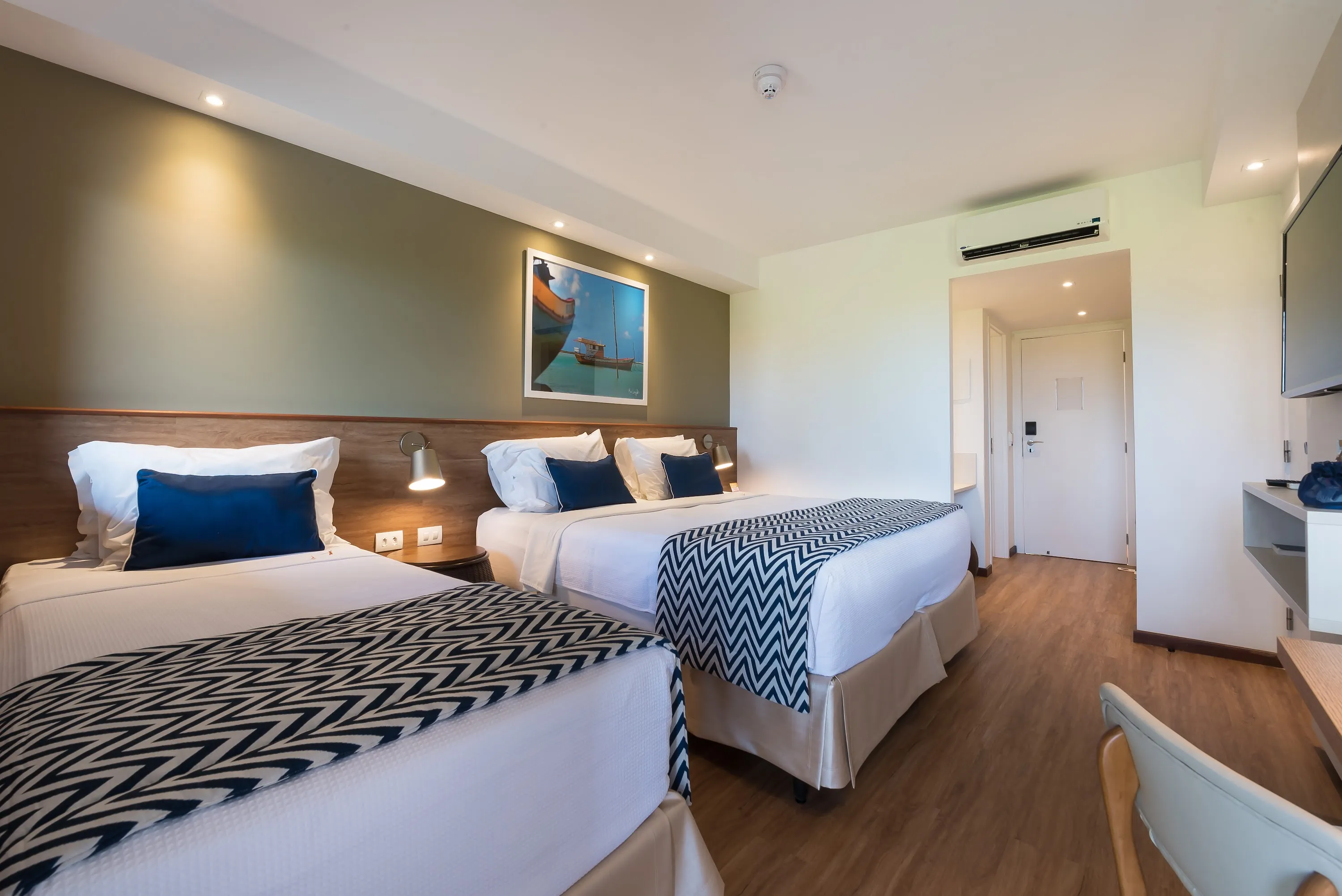 apartamento estandár Apartamento estándar, uno de los alojamientos en Salinas Maragogi, con una cama queen y una cama individual, televisor, mesa y una decoración acogedora con detalles de madera, lámparas y un cuadro de la playa de Maragogi.