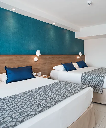 superior salinas maceió Acomodação Superior, do Salinas Maceió All Inclusive Resort, com duas camas queen size, painel de madeira à frente, com TV a cabo, mesa e cadeira e ar condicionado