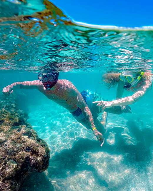 Duas pessoas fazendo mergulho nas piscinas naturais de Maceió.