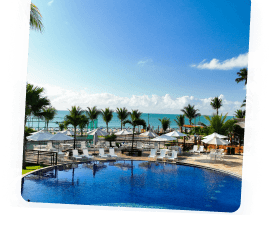 Piscina principal do Salinas Maceió com espreguiçadeiras e vista para o mar