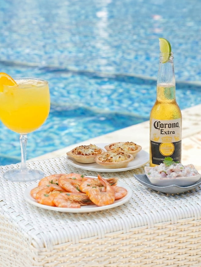 Drinks e petiscos no All Inclusive Drinks amarelo refrescantes, uma long neck da Corona e petiscos servidos na piscina do Salinas Maceió.