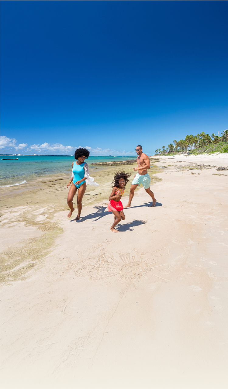 Diversão na Praia do Francês Família brincando na faixa de areia da Praia do Francês em dia ensolarado e sem nuvens. Composta por mãe, pai e filha que estão próximos a água do mar com maré baixa.