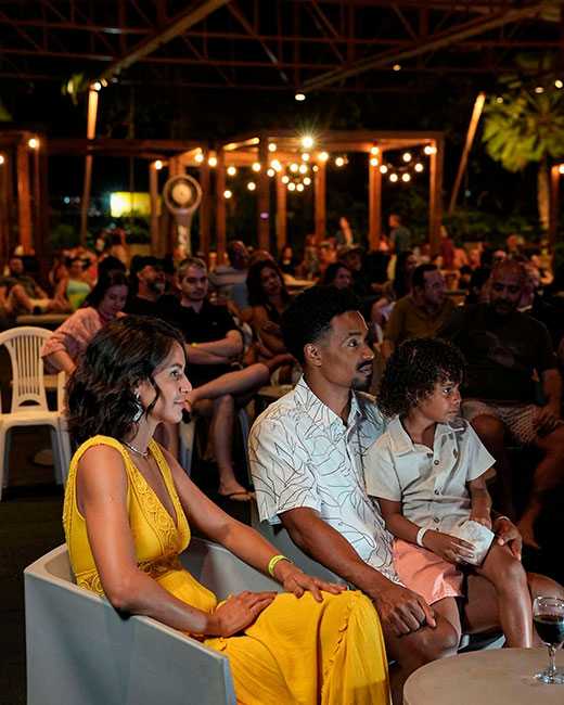 Família assistindo a uma atração noturna no resort.