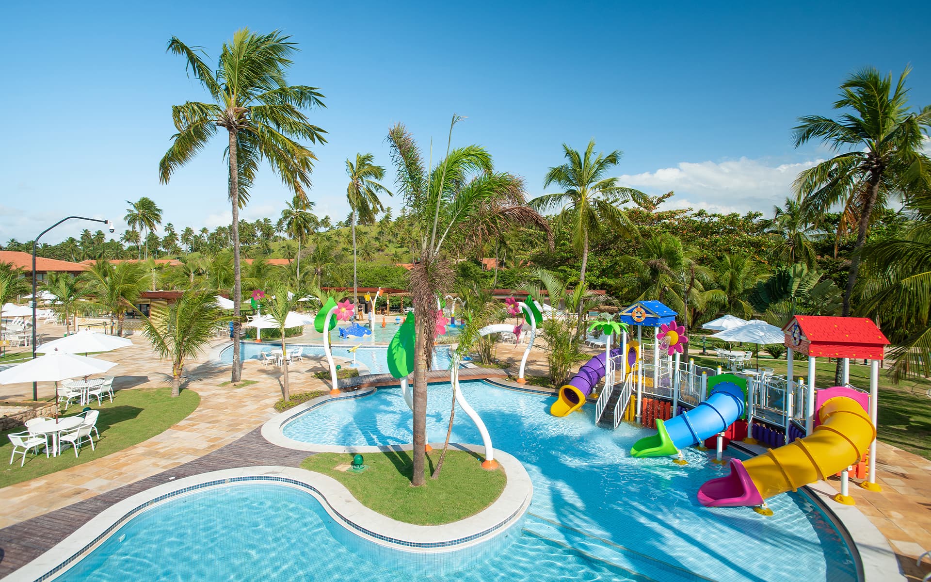 Diversão pra todas as idades Área infantil aquática do Salinas Maragogi com brinquedos pra crianças e cercados por coqueiros.